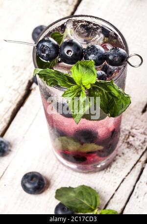Summer cold drink with blueberry, mint and ice on white wooden background Stock Photo