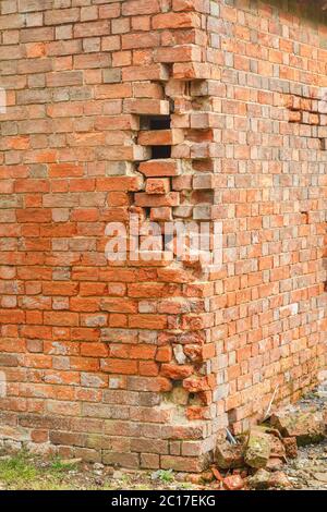 Damage to a brick wall with cracked and missing bricks. UK house subsidence and repairs Stock Photo