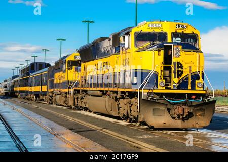 Blue and yellow train of the Alaska Railroad in Anchorage, ready for departure to Denali National Pa Stock Photo
