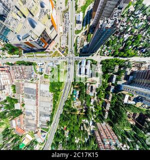 Aerial city view with crossroads and roads, houses, buildings, parks and parking lots. Sunny summer panoramic image Stock Photo