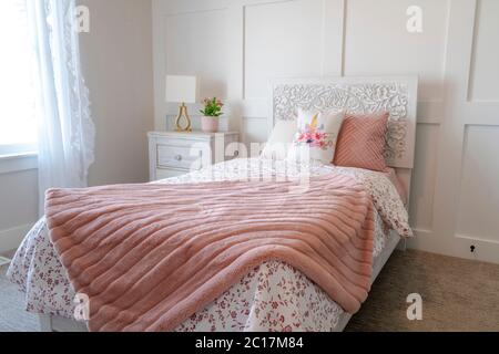 Bedroom interior with decorative headboard and feminine beddings on single bed Stock Photo