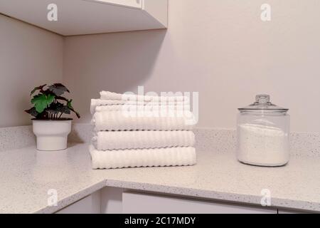 Laundry room with indoor plants folded towels and powder soap on the countertop Stock Photo