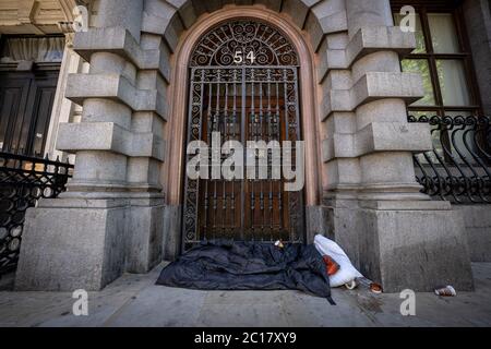 A rough sleeper’s bedding and personal belongings seen during the day in Whitehall, London, UK Stock Photo