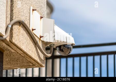 Outdoor cctv security dome camera installed on the exterior wall of a building Stock Photo