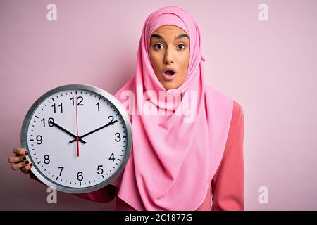 Young Beautiful Arab Woman Wearing Pink Muslim Hijab Doing Countdown Holding Big Clock Scared In Shock With A Surprise Face Afraid And Excited With F Stock Photo Alamy