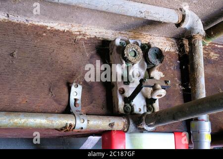 Antique porcelain block fuse switch circuit breaker; architectural breaker knife switches with mica fuse sockets screwed onto a wood beam. Stock Photo