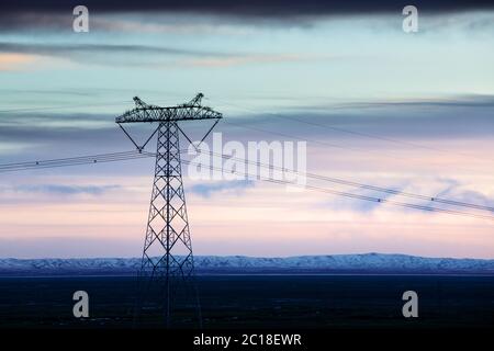 power pylon in wild field with white snow Stock Photo