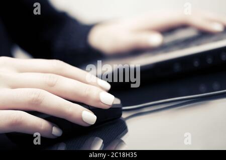 Woman using computer mouse and keyboard Stock Photo