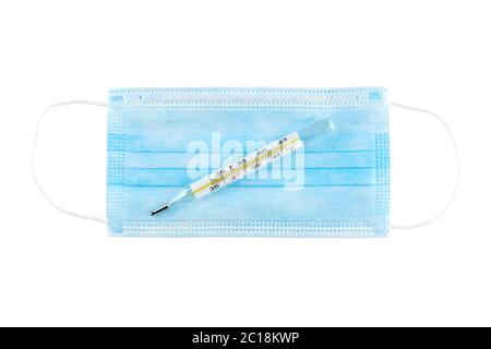 Mercurial thermometer and blue medical face mask isolated on white. Stock Photo