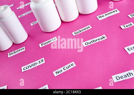 White plastic bottles with pills and coronavirus, pandemic headline clipping words on pink background. Stock Photo