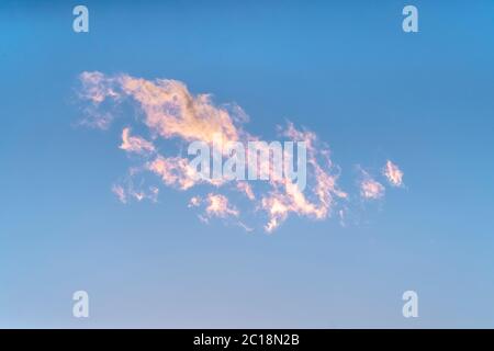 Wispy white clouds tinged pink at sunset Stock Photo