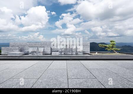 empty marble floor with green hill in cloud sky Stock Photo