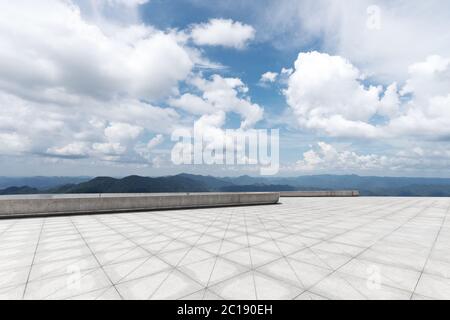 empty marble floor with green hill in cloud sky Stock Photo