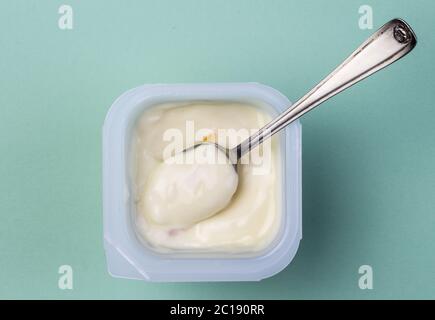 Healthy peach - apricot fruit flavored yoghurt with natural coloring in plastic cup isolated on gree Stock Photo
