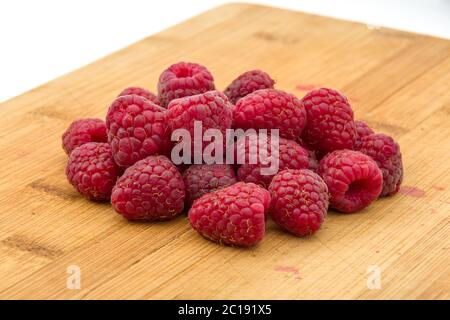 Ripe sweet raspberries on wood table close-up Stock Photo