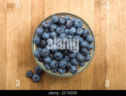 fresh blueberries in white bowl on wood table Stock Photo