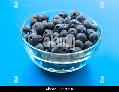 ripe blueberries in bowl isolated on cyan Stock Photo
