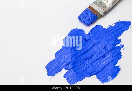 Abstract ultramarine blue brush stroke texture with old used paint brush on white background Stock Photo