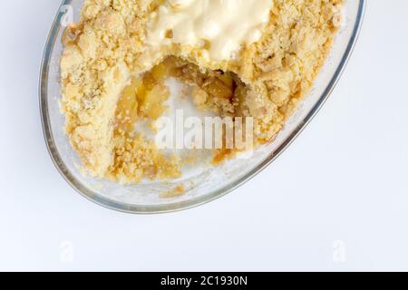 Cooked cinnamon apple crumble pie in glass oval dish on white background - Top view Stock Photo