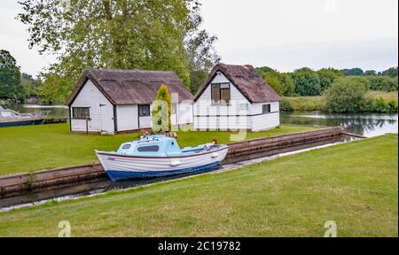 Private mooring dyke and boat house off the River Bure in the village of Coltishall in the heart of the Norfolk Broads Stock Photo