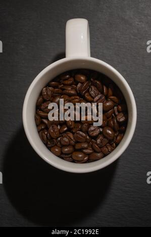 Coffee beans in white coffee mug on dark background Stock Photo