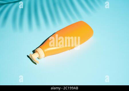 Orange container for cosmetics without label lies on blue background Stock Photo