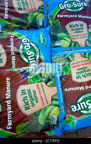 A stack of bags of Farmyard Manure  improving soil quality and promoting plant growth  for sale  in a garden centre Stock Photo