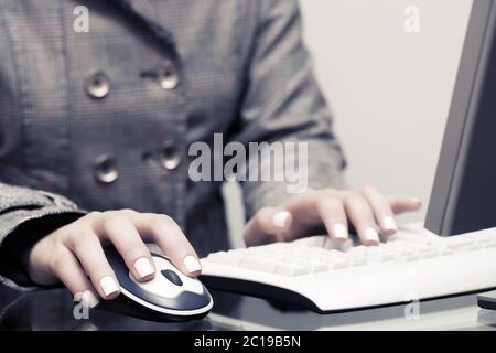 Woman using computer mouse and keyboard Stock Photo