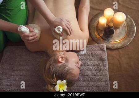 Woman getting thai herbal compress massage in spa Stock Photo