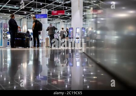Duesseldorf, Germany. 15th June, 2020. Travellers wait at Düsseldorf Airport before checking in their luggage and are reflected in a window pane. After the travel warning for 27 European countries was lifted in the night to Monday (15.06.2020), this morning for the first time ever a plane with holidaymakers took off from Düsseldorf Airport after a corona break of weeks. According to an airport spokesman, Tui-Flight X3 2312 to the Mediterranean island of Mallorca took off at 8.55 a.m. - with a 45-minute delay. Credit: Marcel Kusch/dpa/Alamy Live News Stock Photo