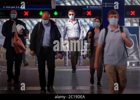 Passengers wearing face masks at Waterloo station in London as face coverings become mandatory on public transport in England with the easing of further lockdown restrictions during the coronavirus pandemic. Stock Photo
