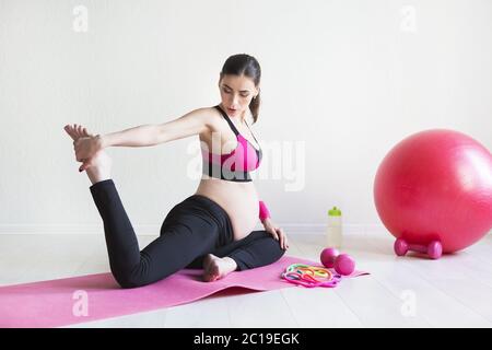 One young pregnant women doing fitness exercises Stock Photo