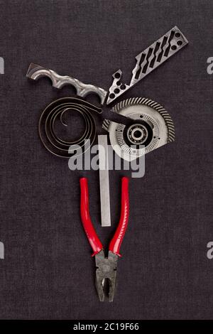 Screws, cogwheels and mechanical components on concrete. Stock Photo