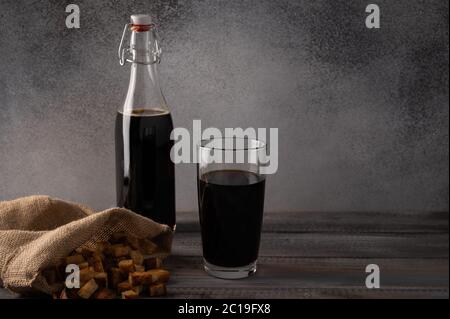 Homemade tradishional russian kvass with glass cup and crackers in a bag. Wonderful healthy refreshing drink for summer Stock Photo
