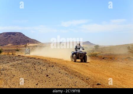 Young man riding quad bike in desert Stock Photo