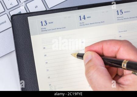 Human hand writing daily work in diary Stock Photo