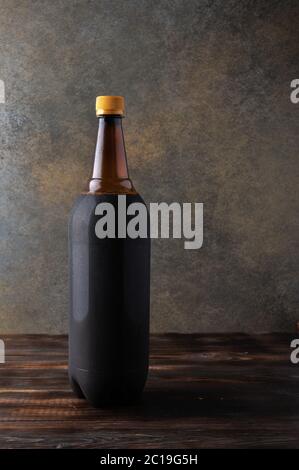 Dark brown plastic bottle of beer or kvass on wooden background with copy space for text. Rustic style Stock Photo