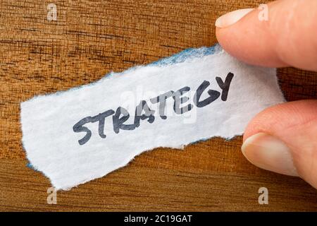 Strategy concept and theme written on old paper on a grunge background Stock Photo