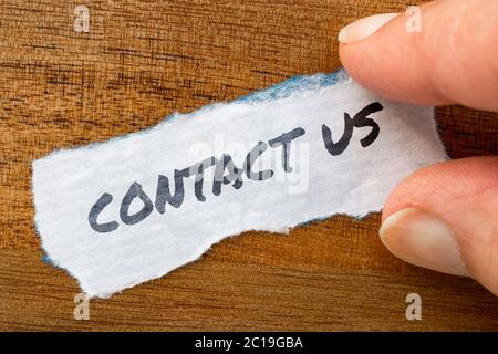 Contact us concept and theme written on old paper on a grunge background Stock Photo