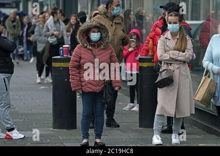 Shoppers wear face masks in the queue for the Primark store on Northumberland Street, Newcastle, as non-essential shops in England open their doors to customers for the first time since coronavirus lockdown restrictions were imposed in March. Stock Photo