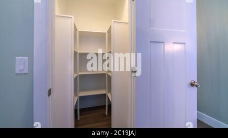 Panorama Empty walk-in closet with framed shelves and metal rods Stock ...