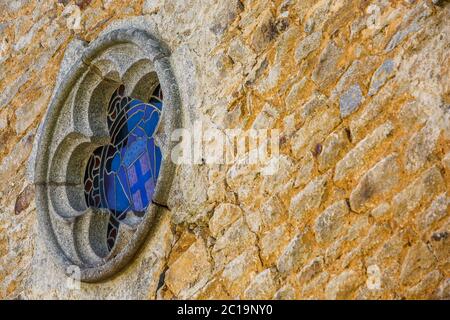 Small church window on a stone wall Stock Photo