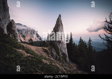Beautiful sunrise landscape with sharp mountain peak,blue sky,illuminated clouds by the sun at Transylvania,Romania Stock Photo