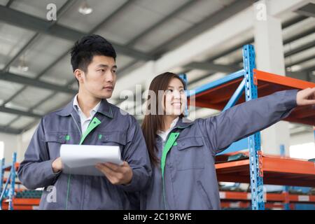 young asian man and woman work in workshop Stock Photo