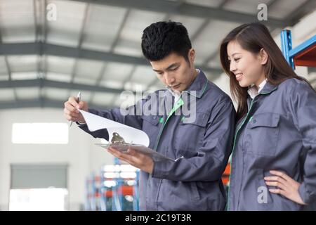 young asian man and woman work in workshop Stock Photo
