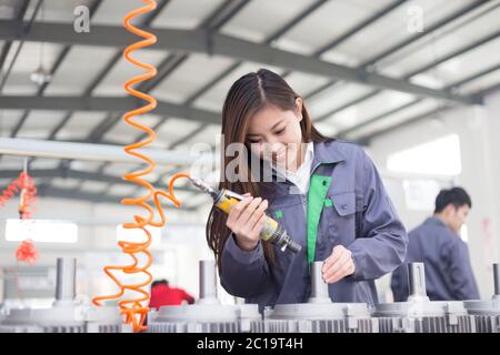 young asian woman works in workshop Stock Photo