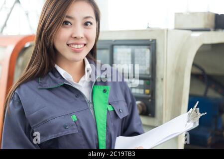 young asian woman works in workshop Stock Photo