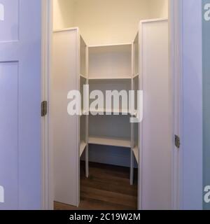 Square Interior of a walk in closet with shelving units and clothes ...