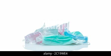 Pile of used surgical face mask isolated on white background. Medical waste. Infectious waste from coronavirus crisis. Pink, green, blue, and white Stock Photo