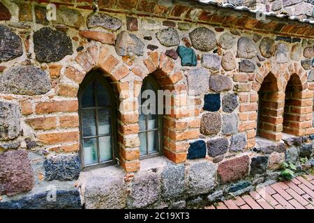 Details of a historic medieval church in Berlin, Germany. You can see a series of windows in a field stone wall. Stock Photo